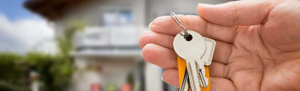 A hand holding a set of keys to a home